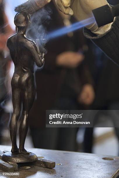 Patina artist Ricardo Godinez puting a finishing touch on one of the bronze Screen Actors Guild Award statuettes at the American Fine Arts Foundry on...