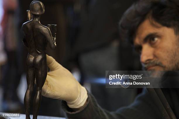 Patina artist Ricardo Godinez puting a finishing touch on one of the bronze Screen Actors Guild Award statuettes at the American Fine Arts Foundry on...