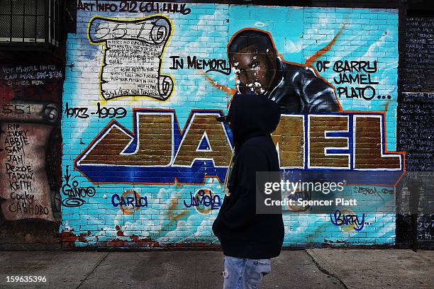 Man walks by a graffiti memorial on a wall in memory of an individual killed in the Bedford-Stuyvesant neighborhood on January 17, 2013 in the...