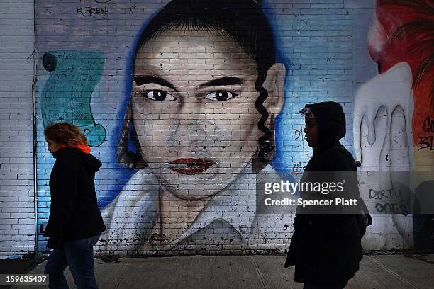 Women walk by a graffiti memorial in memory of a woman in the Bedford-Stuyvesant neighborhood on January 17, 2013 in the Brooklyn borough of New York...