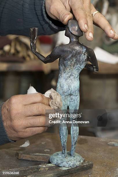 Patina artist Joaquin Quintero puting a finishing touch on one of the bronze Screen Actors Guild Award statuettes at the American Fine Arts Foundry...