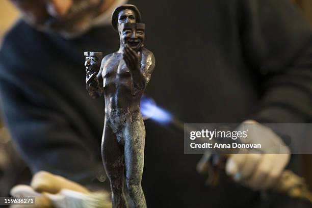 Patina artist Ricardo Godinez puting a finishing touch on one of the bronze Screen Actors Guild Award statuettes at the American Fine Arts Foundry on...