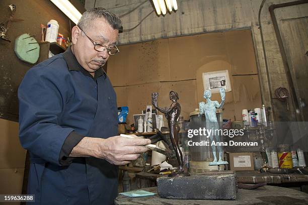 Patina artist Joaquin Quintero puting a finishing touch on one of the bronze Screen Actors Guild Award statuettes at the American Fine Arts Foundry...