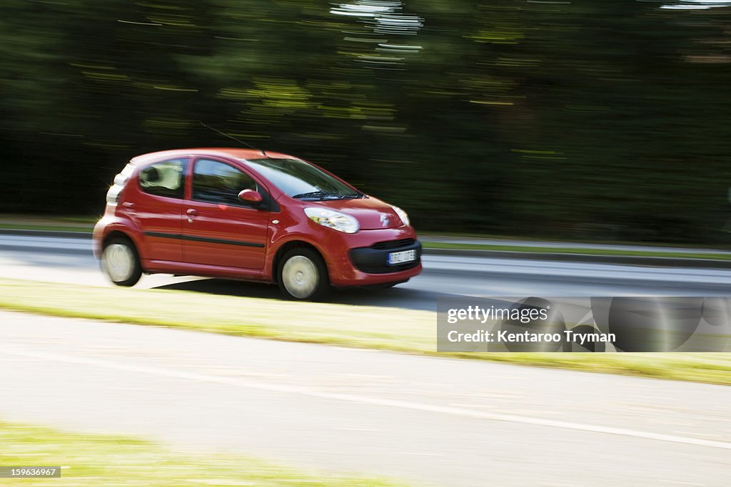 Red car moving fast on highway