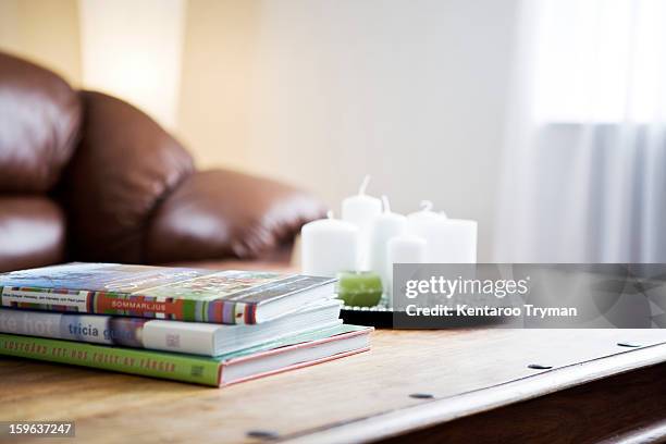 stack of books with a tray of candles on table - coffee table books stockfoto's en -beelden