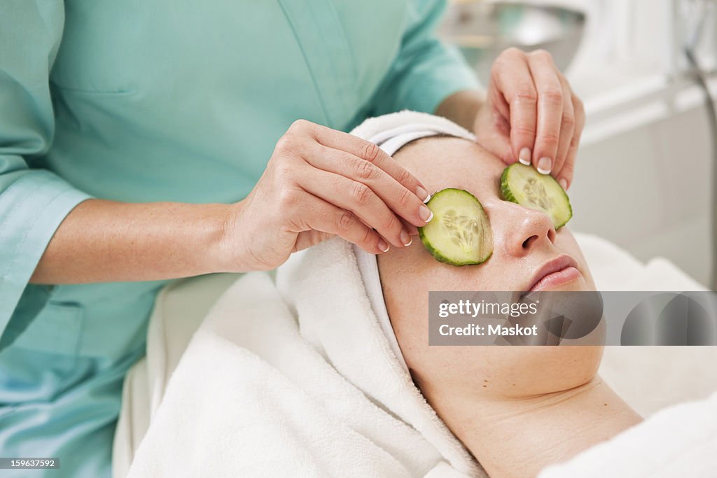 Midsection of beautician giving a beauty treatment to young woman in spa