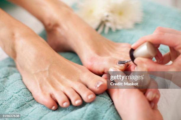 close-up of a female feet receiving a beauty treatment for nails in spa - pedicure foto e immagini stock