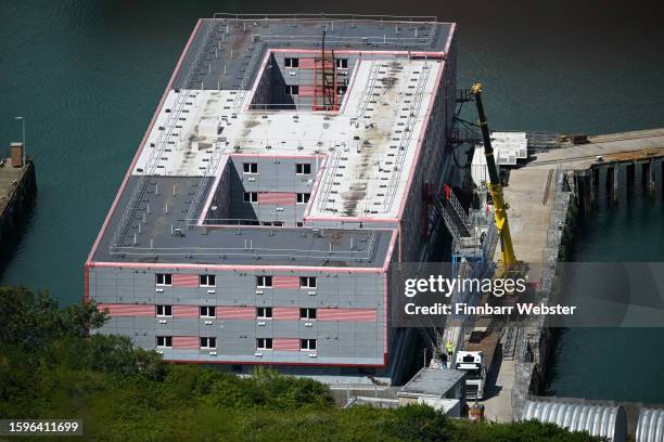 Crane lifts a gangway into place on the Bibby Stockholm immigration barge moored at Portland Port, on August 06, 2023 in Portland, England, The Home...