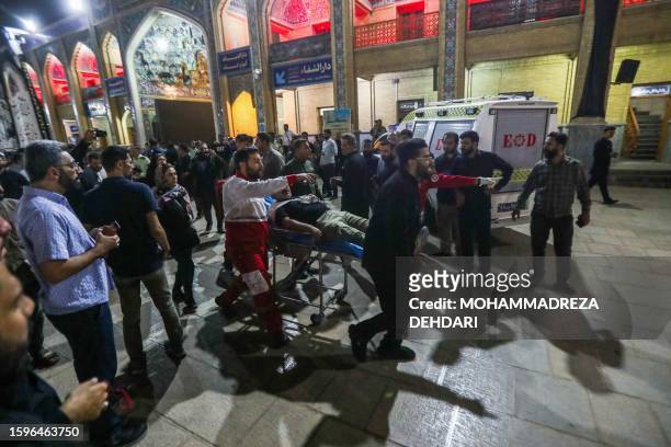 Emergency personnel transport the injured following a shooting attack at Iran's Shah Cheragh mausoleum in the Fars province capital Shiraz, on August...