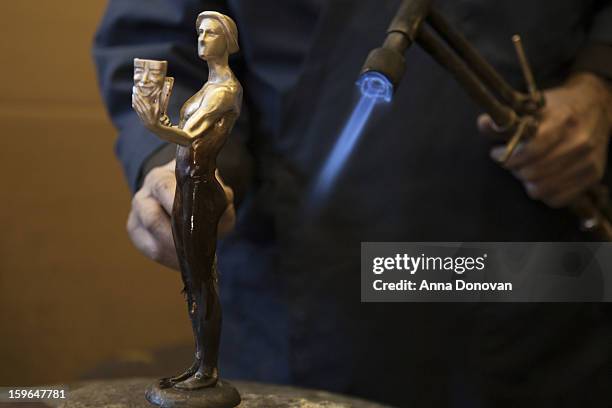 Patina artist Joaquin Quintero puting a finishing touch on one of the bronze Screen Actors Guild Award statuettes at the American Fine Arts Foundry...