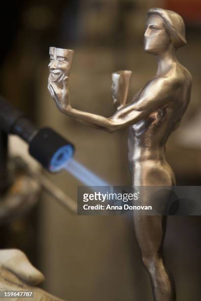 Patina artist Paul Napier puting a finishing touch on one of the bronze Screen Actors Guild Award statuettes at the American Fine Arts Foundry on...