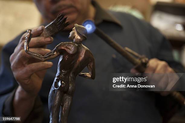 Patina artist Joaquin Quintero puting a finishing touch on one of the bronze Screen Actors Guild Award statuettes at the American Fine Arts Foundry...