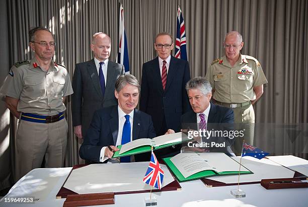 Foreign Secretary for the UK, William Hague and Australian Foreign Minister Bob Carr look on as the UK Defence Secretary Philip Hammond and...