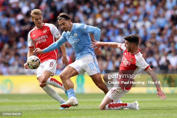 Martin Odegaard of Arsenal, Jack Grealish of Manchester City and Declan Rice of Arsenal battle for the ball during The FA Community Shield match...