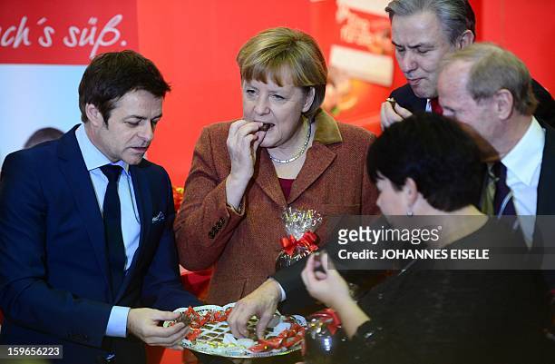 German Chancellor Angela Merkel , Berlin Mayor Klaus Wowereit taste chocolate during the opening of the Gruene Woche Agricultural Fair in Berlin on...