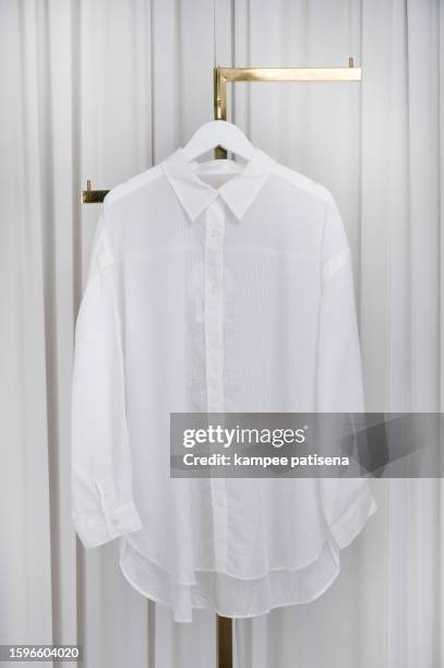 chic women's dress shirt hanging gracefully - stylish fashion concept - white shirt stock pictures, royalty-free photos & images