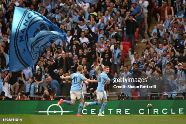 Cole Palmer of Manchester City celebrates with teammate Kevin De Bruyne after scoring the team's first goal during The FA Community Shield match...