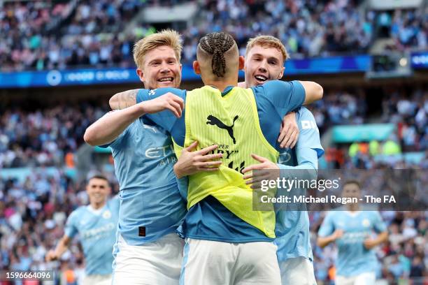 Cole Palmer of Manchester City celebrates with teammates Kevin De Bruyne and Kalvin Phillips after scoring the team's first goal during The FA...