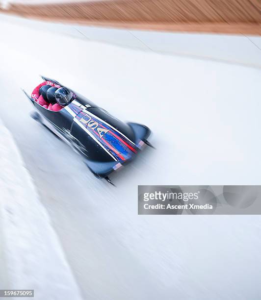 bobsled descends track with speed, motion blur - bobsleigh team stock pictures, royalty-free photos & images
