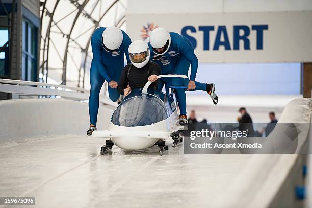 bobsledders push bobsled out of start gate - sport and team photos et images de collection