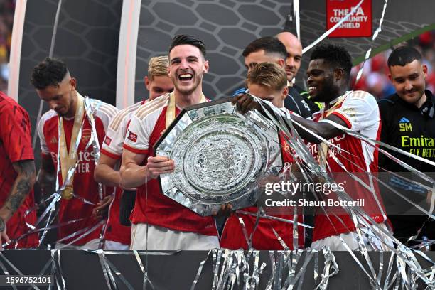 Declan Rice of Arsenal lifts the FA Community Shield Trophy with teammate Thomas Partey following the team's victory after the penalty shootout...