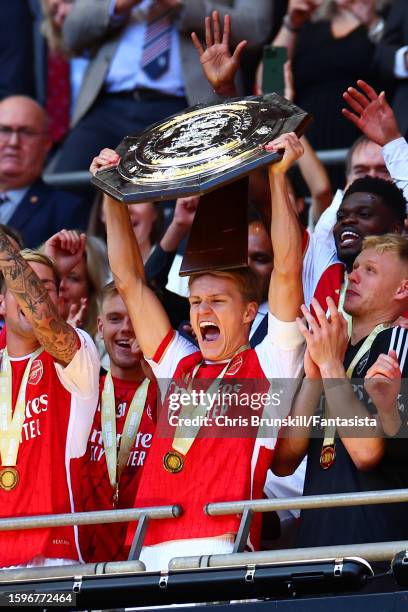 Martin Odegaard of Arsenal lifts the trophy following The FA Community Shield match between Manchester City against Arsenal at Wembley Stadium on...