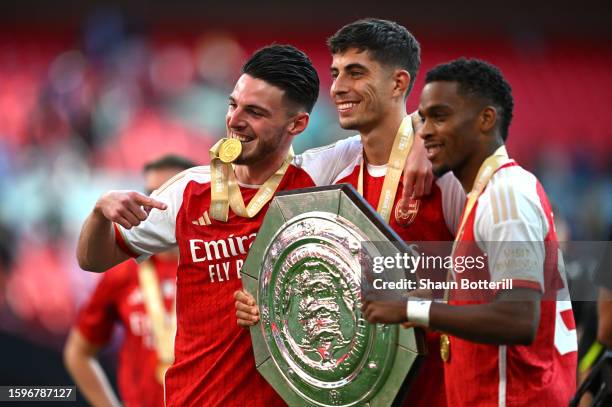 Declan Rice, Kai Havertz and Jurrien Timber of Arsenal celebrate with the FA Community Shield Trophy following the team's victory in the penalty...