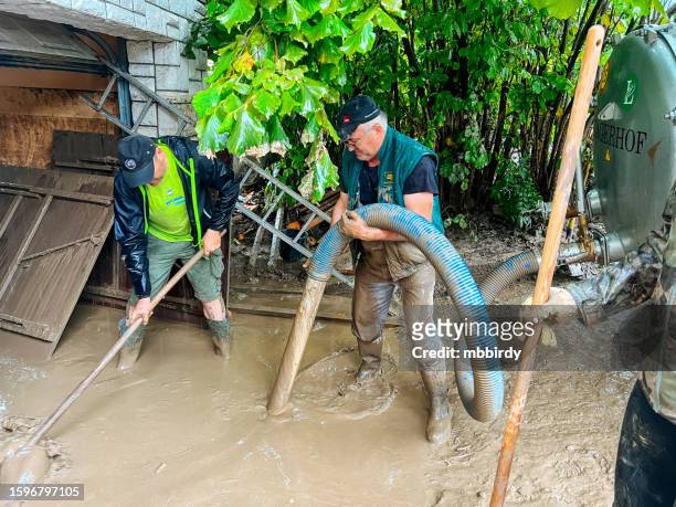 men removing river silt residue with after flooding - flood cleanup stock pictures, royalty-free photos & images