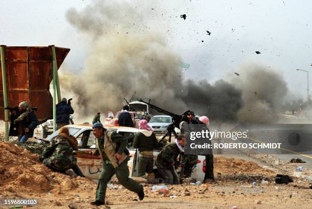 Shrapnels fly through the air as a tank shell explodes near Libyan rebel fighters defending their last position against Moamer Kadhafi's loyalist...