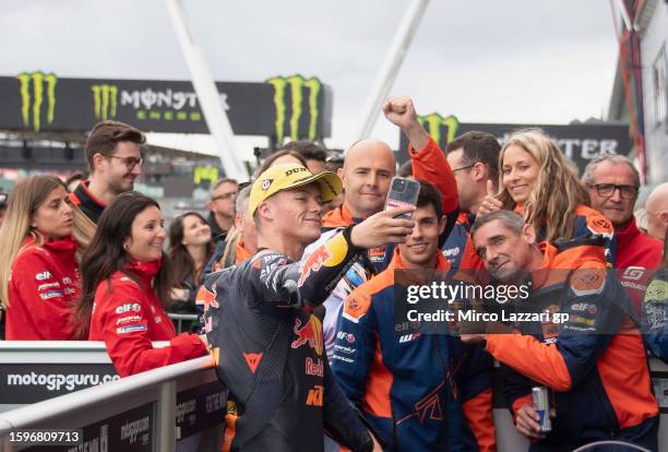 Daniel Holgado of Spain and Red Bull KTM Tech3 celebrates the third place with team under the podium during the Moto3 race during the MotoGP of Great...