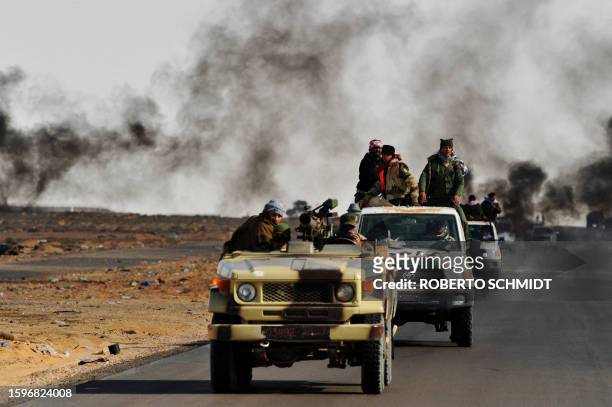 Convoy of Libyan rebel fighters heads towards the front line on March 11, 2011 as rebels battled troops loyal to Moamer Kadhafi outside Ras Lanuf a...