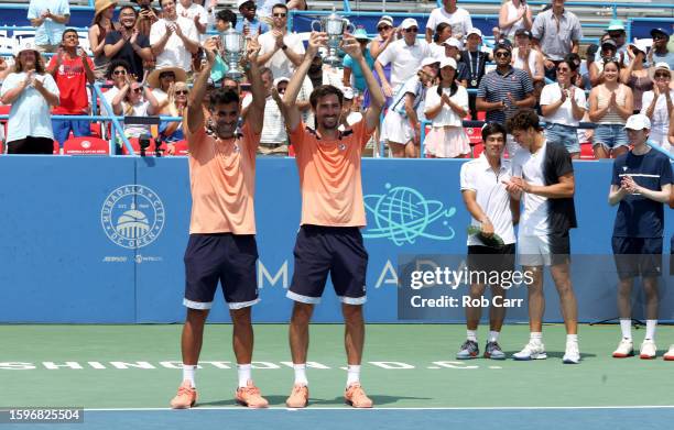 Maximo Gonzalez and Andres Molteni of Argentina hold up the trophy after defeating Mackenzie McDonald and Ben Shelton of the United States to win the...