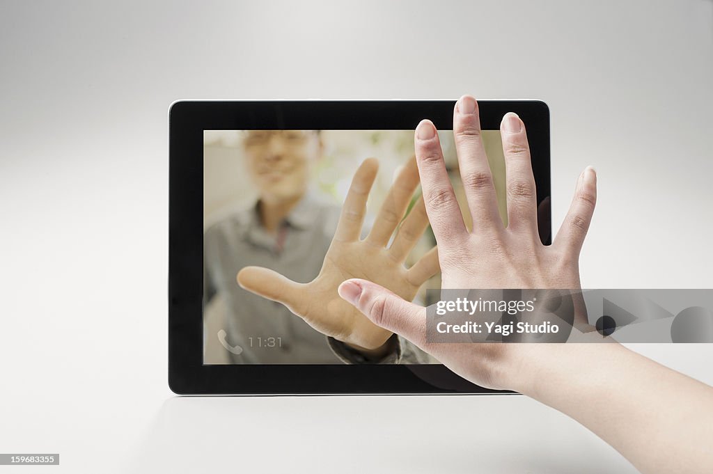Woman talking to man over internet on tablet
