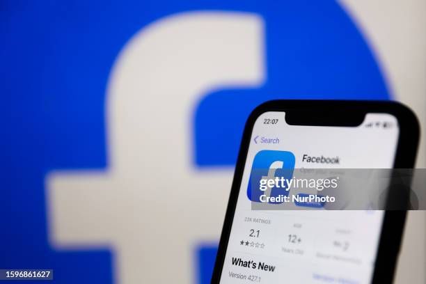Facebook on App Store displayed on a phone screen and Facebook logo displayed on a screen in the background are seen in this illustration photo taken...