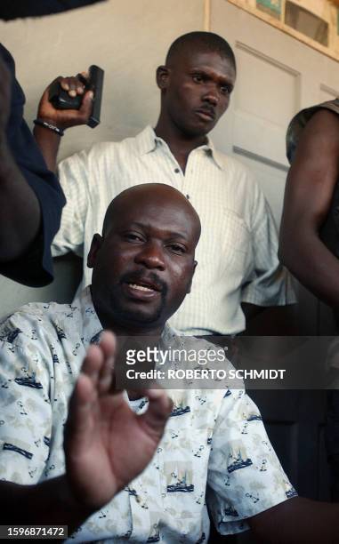 Buteur Metayer , one of the leaders of the Anti-Aristide Resistance Front, is surrounded by armed rebels as he speaks to members of the press in...