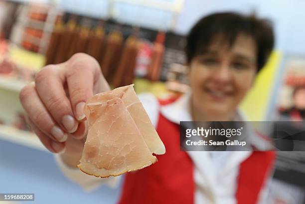 Saleswoman presents the photographer with a slice of dried ham at the 2013 Gruene Woche agricultural trade fair on January 18, 2013 in Berlin,...