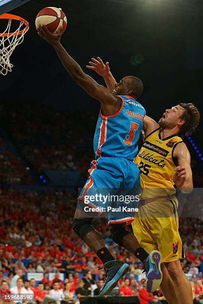 Jamar Wilson of the Taipans lays up against Jeremiah Trueman of the Wildcats during the round 15 NBL match between the Perth Wildcats and the Cairns...