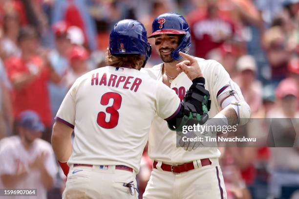 Bryce Harper and Nick Castellanos of the Philadelphia Phillies react after a two run home run hit by Castellanos during the fifth inning against the...