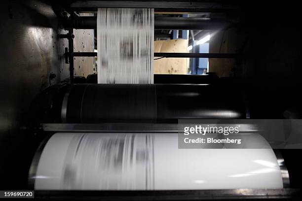 Printed pages run through the presses at the Kathimerini printing plant in Paiania, Greece, on Thursday, Jan. 17, 2013. An anarchist group claimed...
