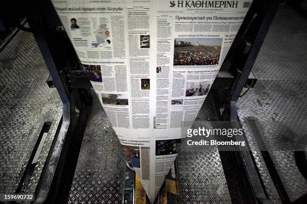 Newly-printed pages of the Kathimerini newspaper pass along the automated production line at the Kathimerini printing plant in Paiania, Greece, on...