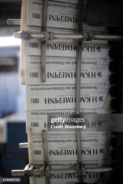 Newly-printed editions of the Kathimerini newspaper pass along the automated production line at the Kathimerini printing plant in Paiania, Greece, on...