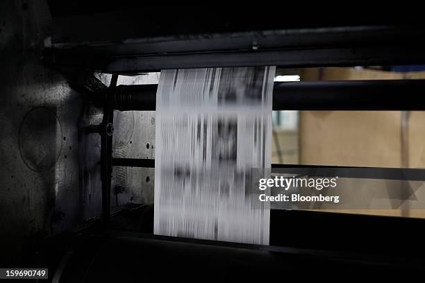 Newly-printed pages of the Kathimerini newspaper pass along the automated presses at the Kathimerini printing plant in Paiania, Greece, on Thursday,...