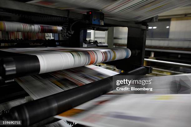 Newly-printed colour newspaper pages pass through the automated presses at the Kathimerini printing plant in Paiania, Greece, on Thursday, Jan. 17,...