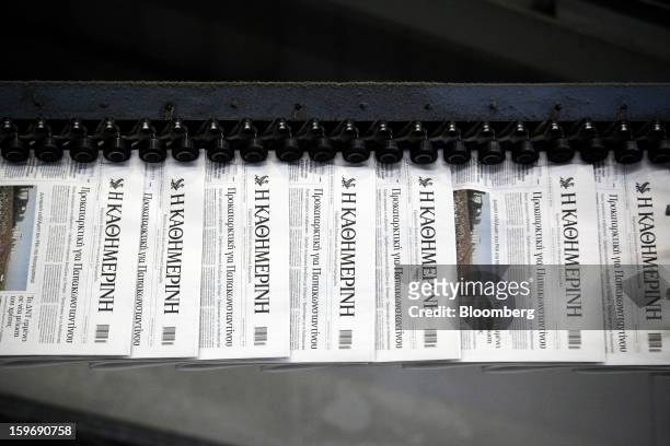 Newly-printed editions of the Kathimerini newspaper pass along an automated production line at the Kathimerini printing plant in Paiania, Greece, on...