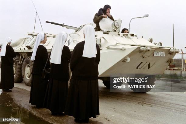 An Ukrainian armoured vehicle passes Catholic nuns waiting to be evacuated on a UN convoy out of Sarajevo, on November 05, 1992. AFP PHOTO PATRICK BAZ