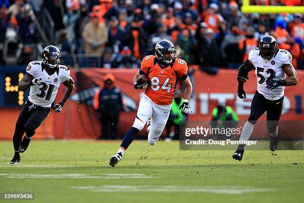 Jacob Tamme of the Denver Broncos runs for yards on a first down reception against Bernard Pollard and Ray Lewis of the Baltimore Ravens during the...