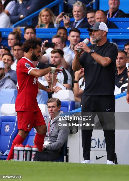 Mohamed Salah of Liverpool reacts as he is substituted as Jurgen Klopp Manager of Liverpool looks on during the Premier League match between Chelsea...