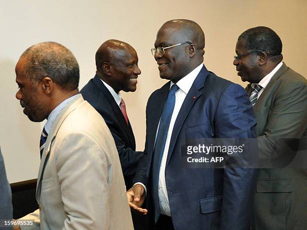 Prime Minister of Ivory Coast Daniel Kablan Duncan shakes hands with leaders of ex-president Laurent Gbagbo's Ivorian Popular Front party, FPI's...
