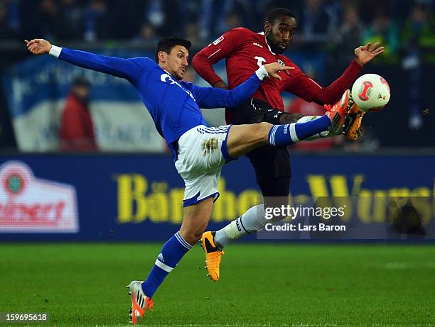 Ciprian Marica of Schalke is challenged by Johan Djourou of Hannover during the Bundesliga match between FC Schalke 04 and Hannover 96 at...