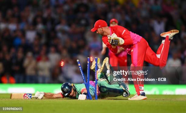 Tom Curran of Oval Invincibles dives to make his ground as Chris Cooke of Welsh Fire attempts to run him out resulting in a tie during The Hundred...